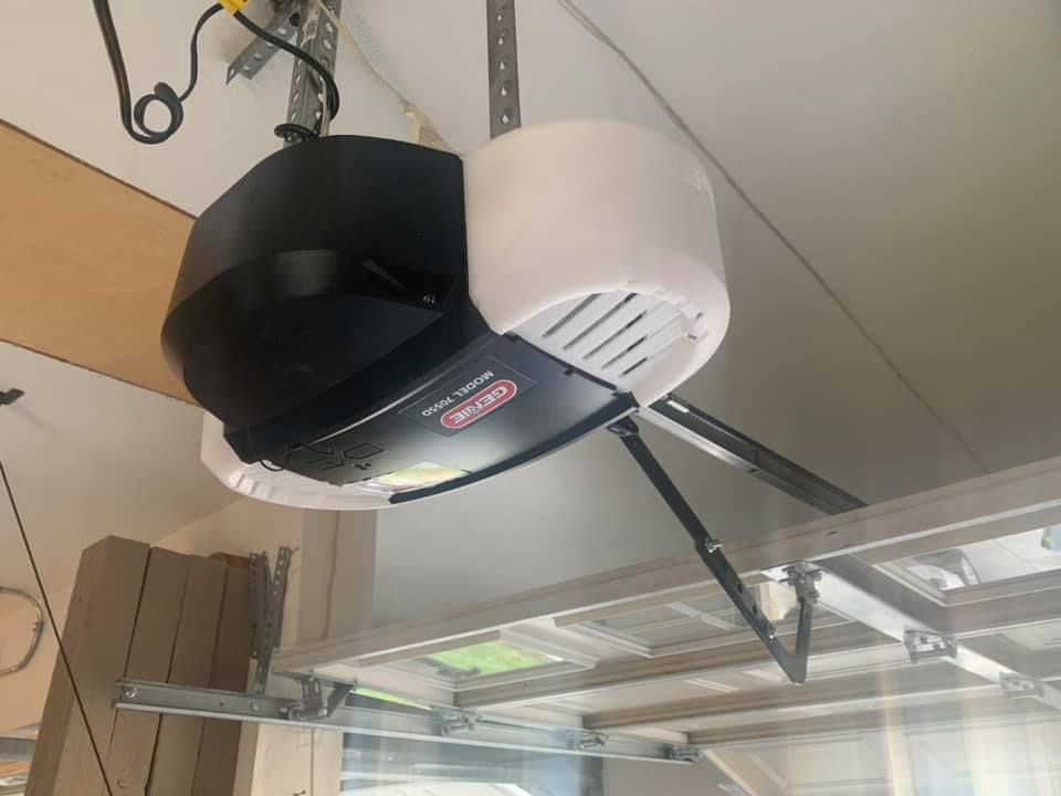 A garage door opener is hanging from the ceiling of a garage.