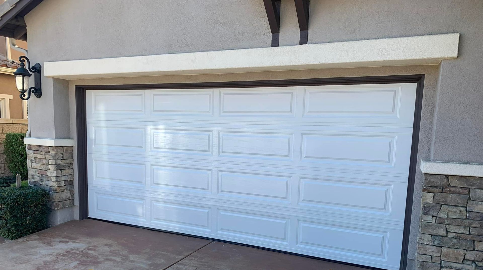 A white garage door is sitting in front of a house.