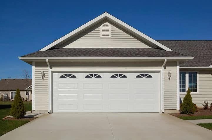 A house with a white garage door and a gray roof