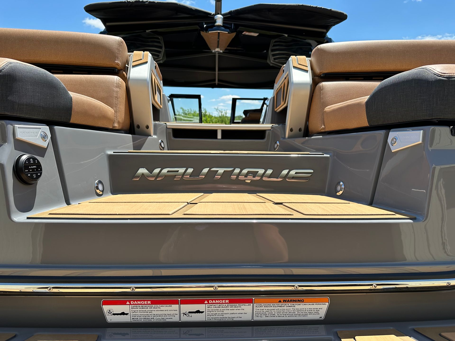 Gray Nautique boat stern with brown seating and a wooden deck.