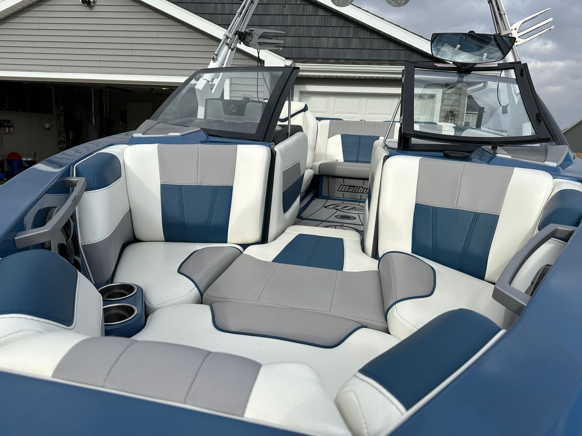 Blue and white boat interior with gray accents, cup holders, and windshields.