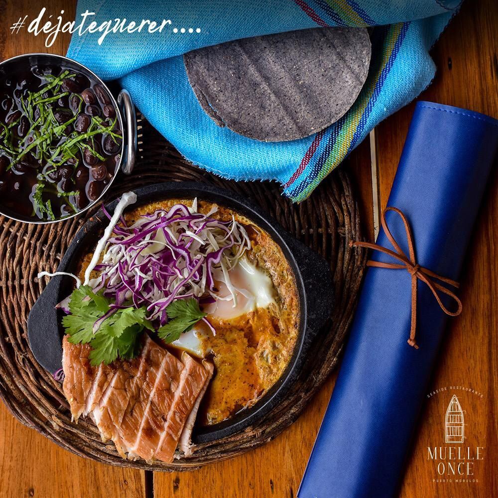 Mexican dish: fried egg, pork, purple cabbage, black beans, tortillas, blue cloth.