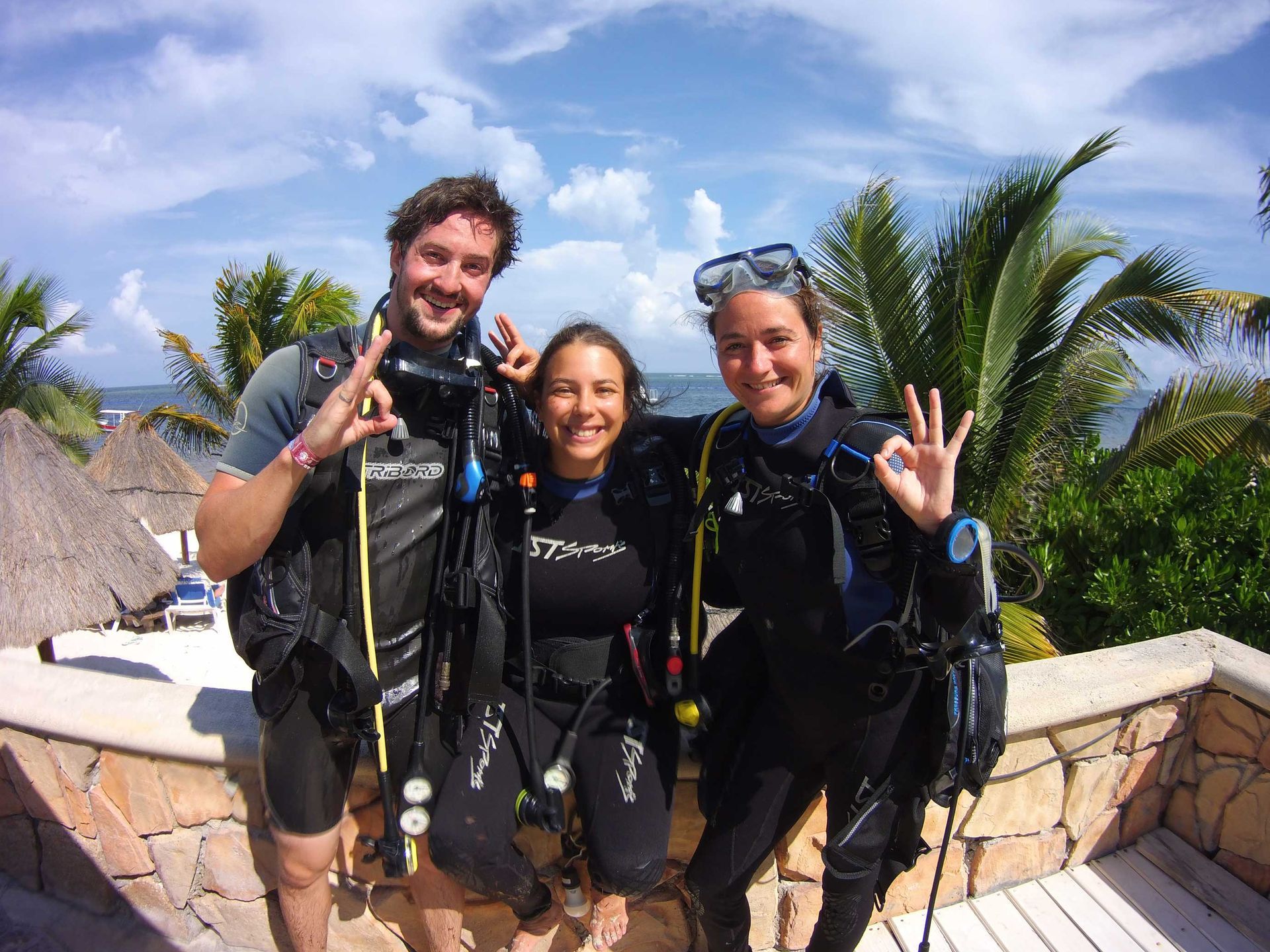 Three people in scuba gear giving