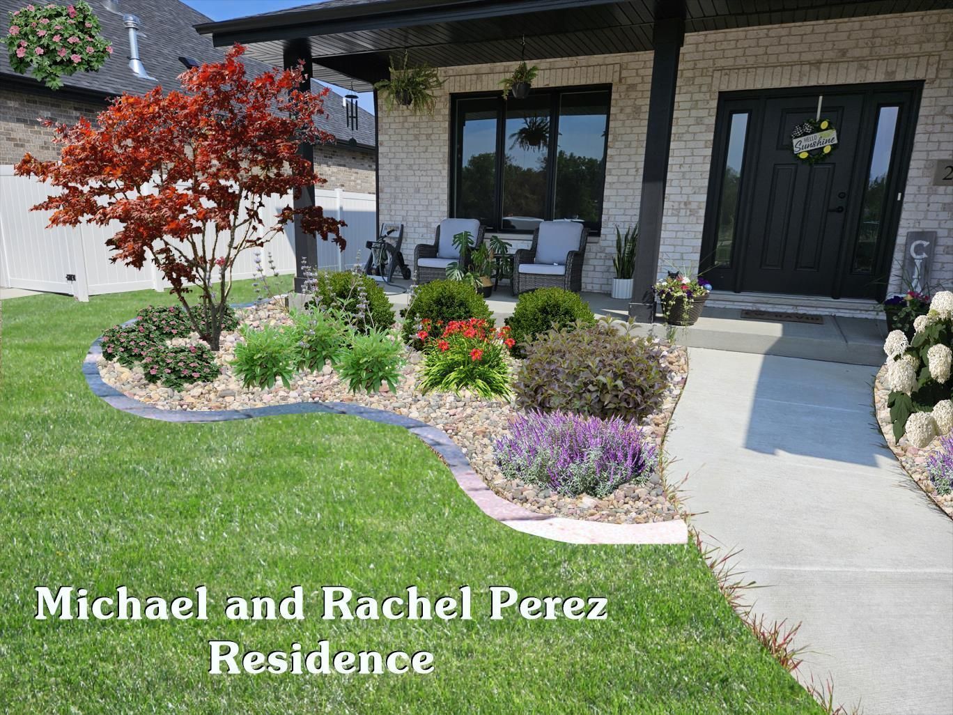 A front garden bed with a red Japanese maple, shrubs, and purple flowers, set in front of a house with white brick.
