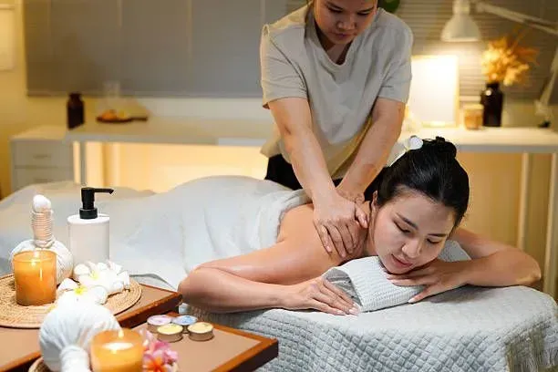 Professional therapist performing a back massage on a mat.