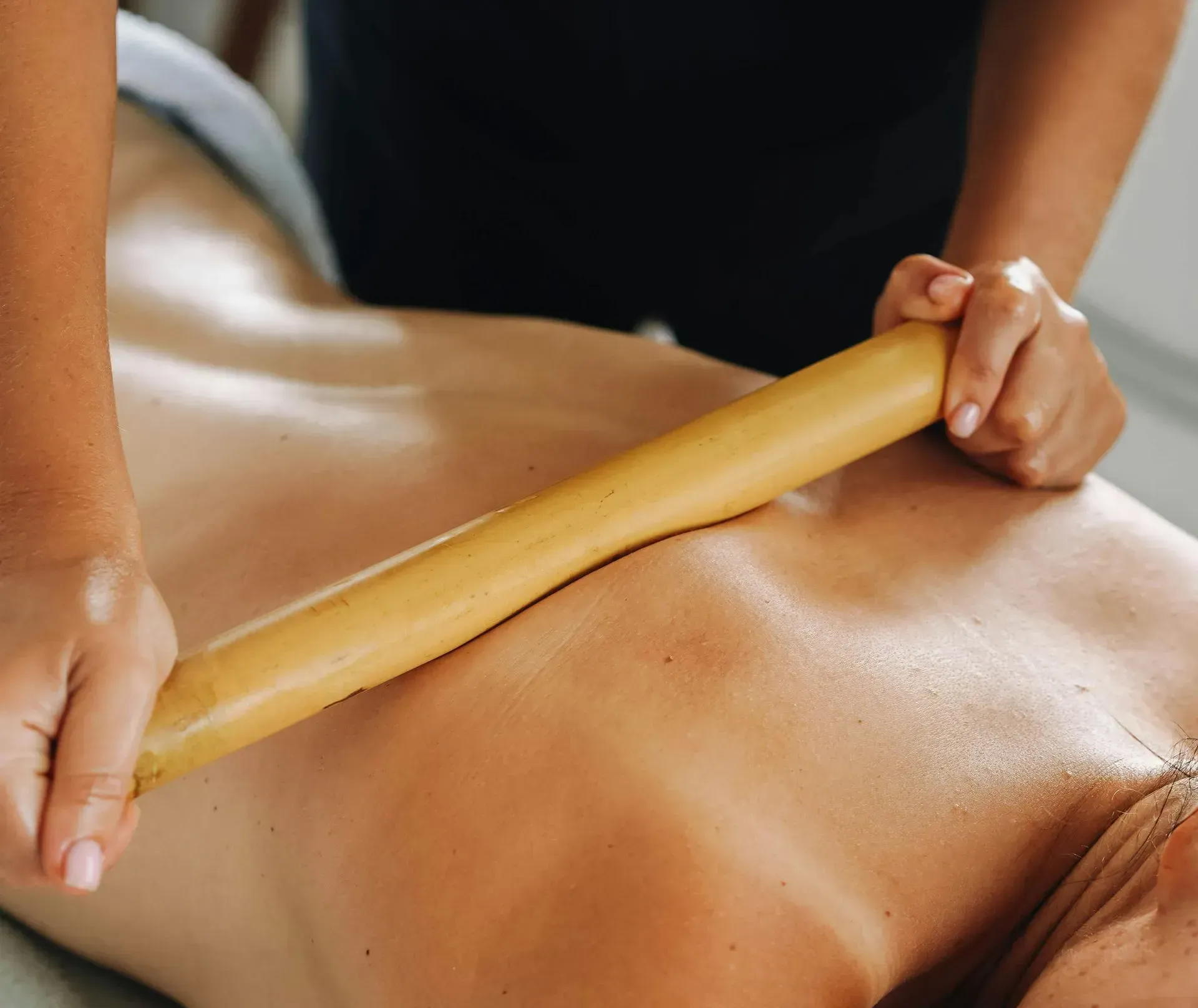 Deep tissue massage using a specialized wooden tool