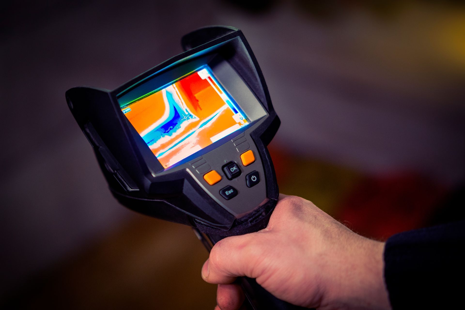 A person is holding a thermal camera in their hand.