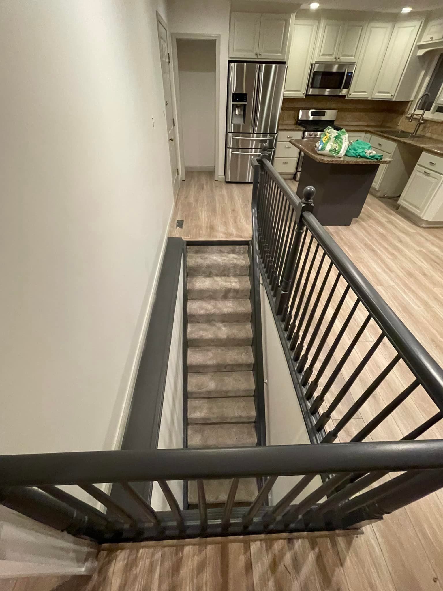 A staircase leading up to a kitchen in a house.