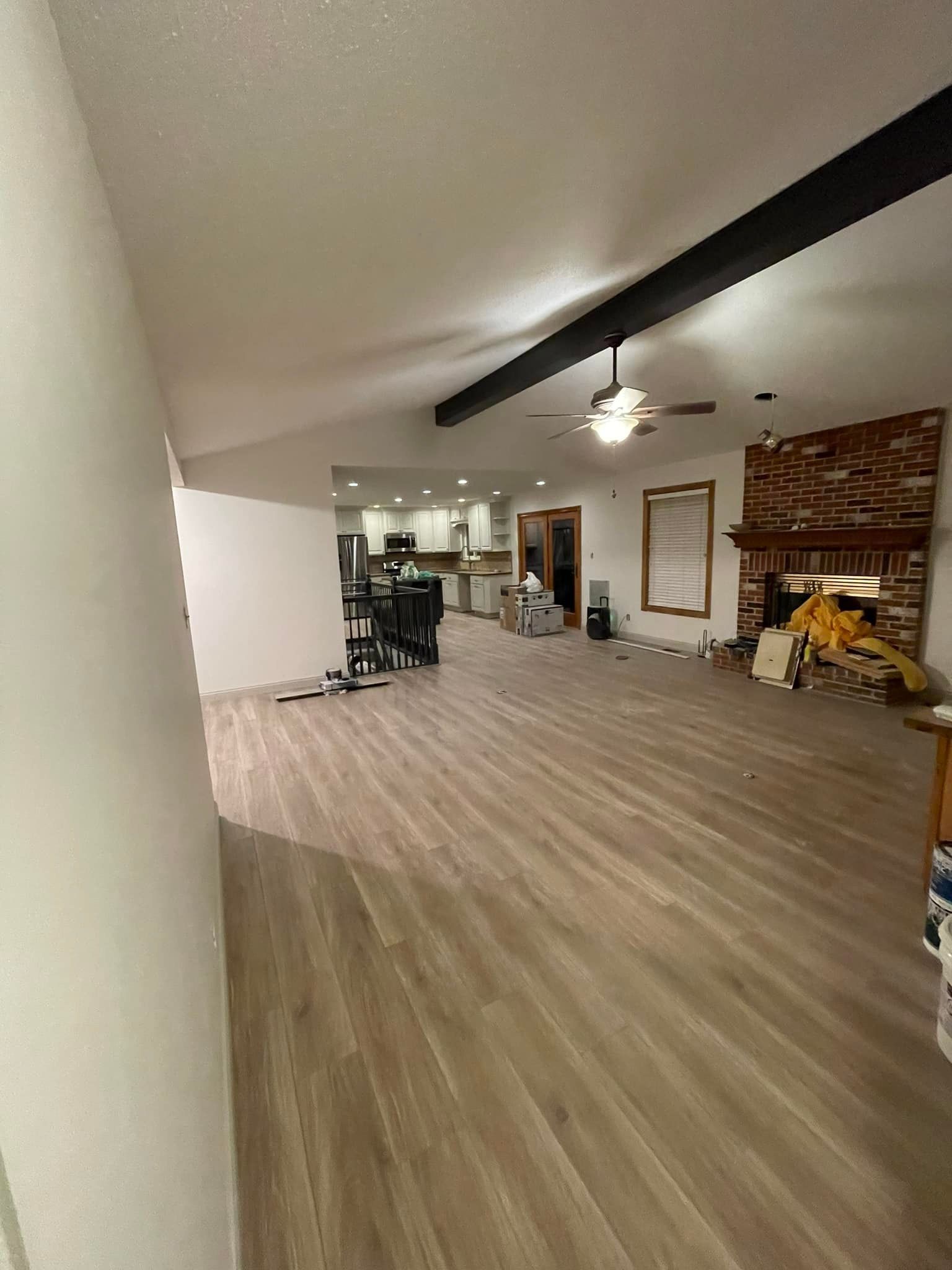 A large living room with hardwood floors and a fireplace.