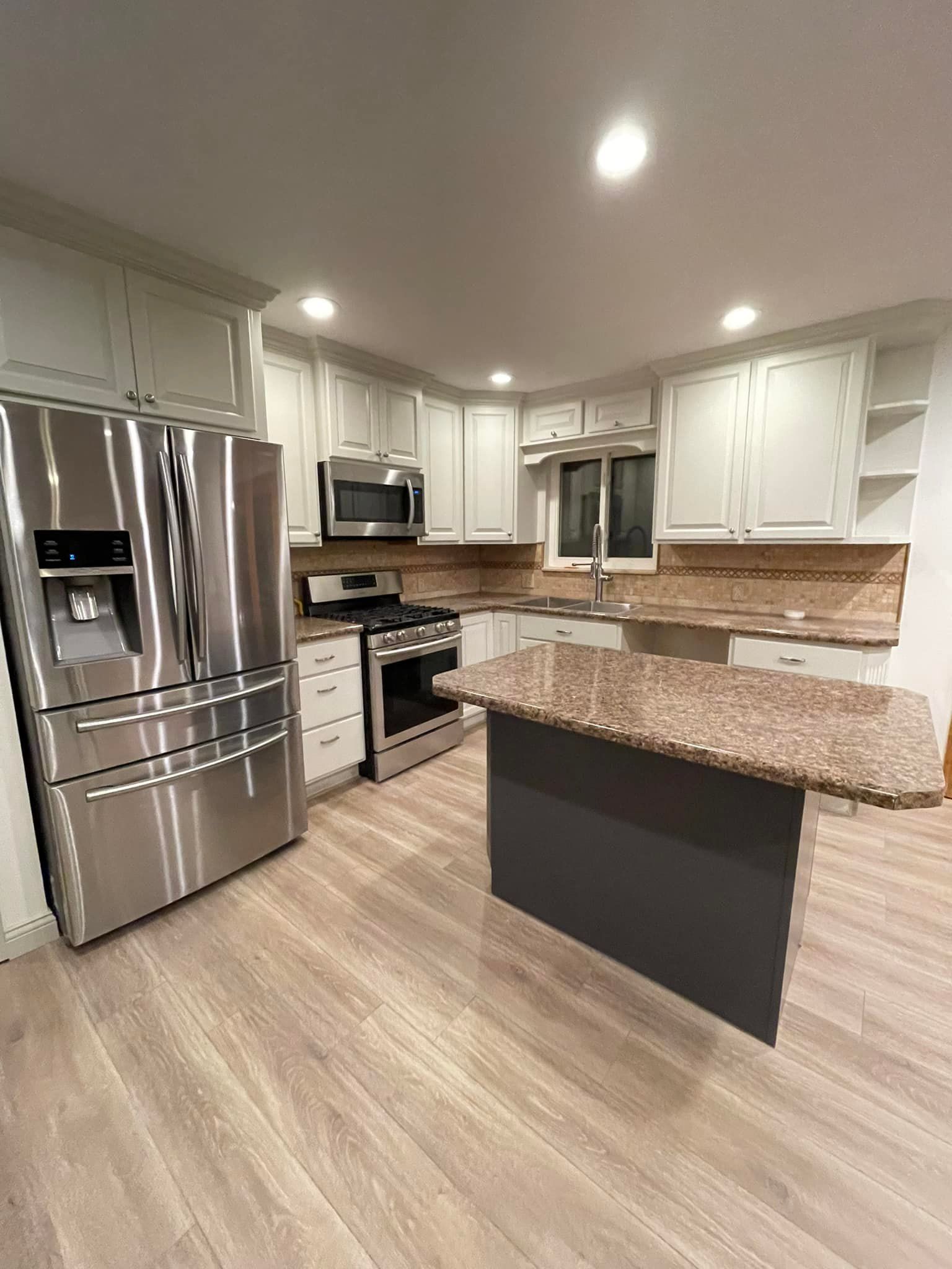A kitchen with stainless steel appliances and granite counter tops.
