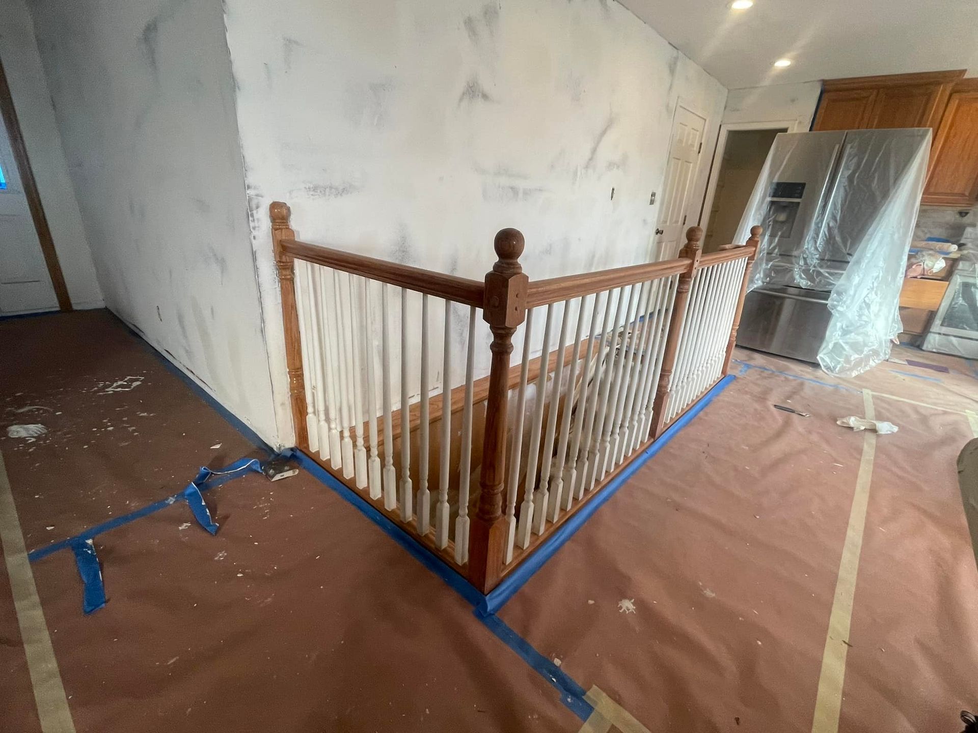 A wooden staircase is being painted in a house.