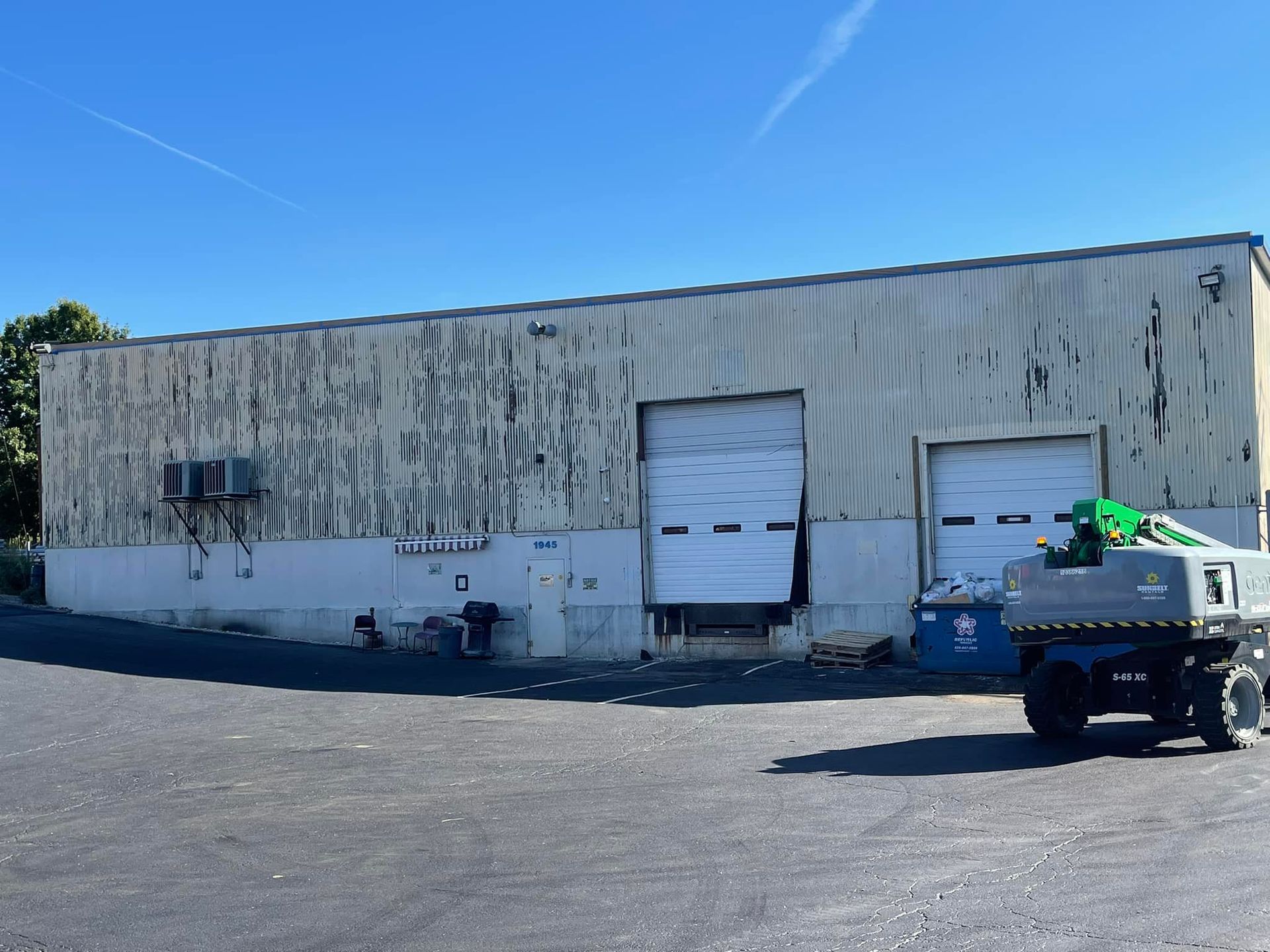 A truck is parked in front of a building with a large garage door.