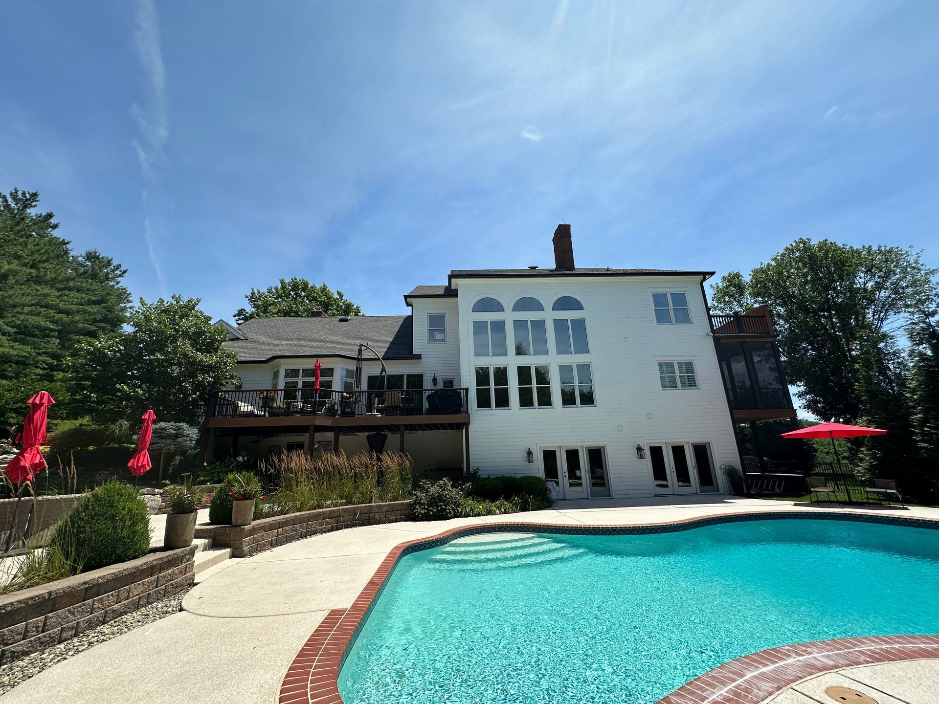 A large white house with a swimming pool in front of it