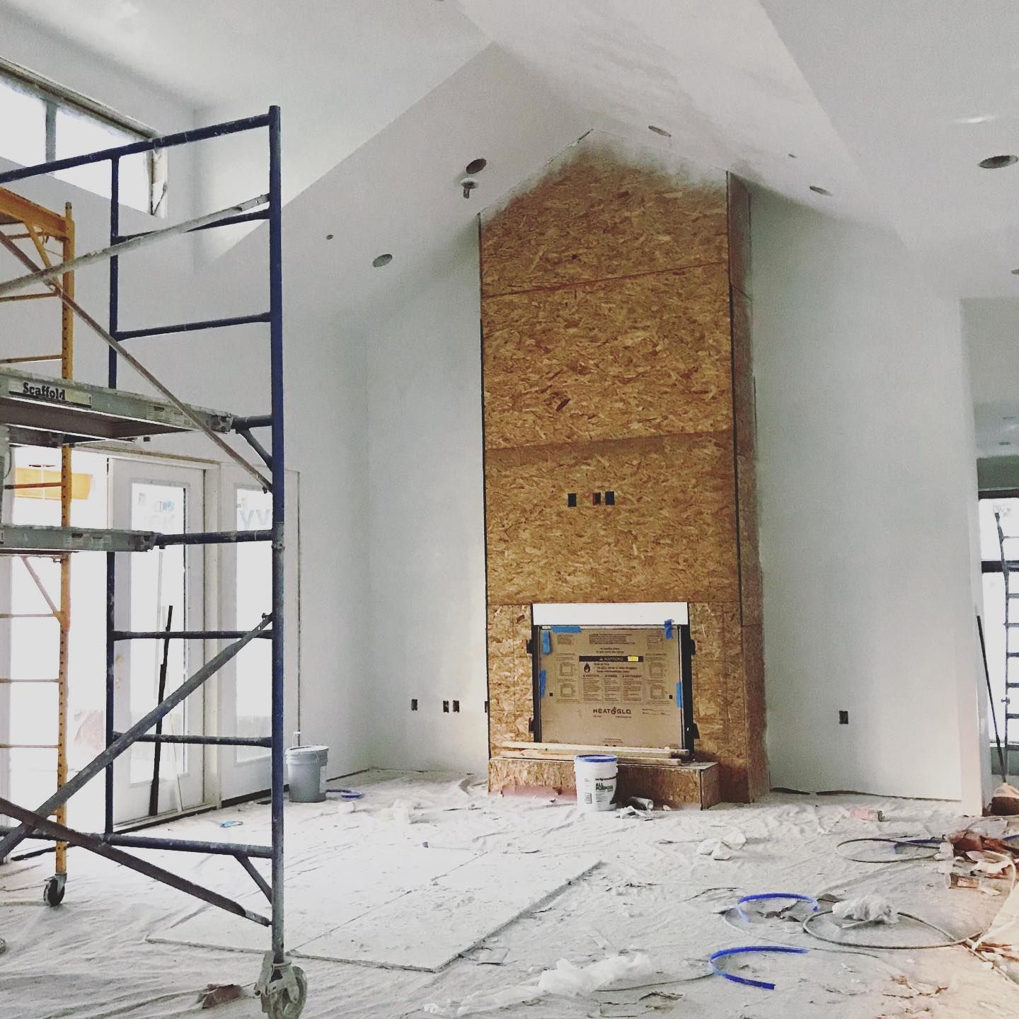 A large room with a fireplace and scaffolding in it