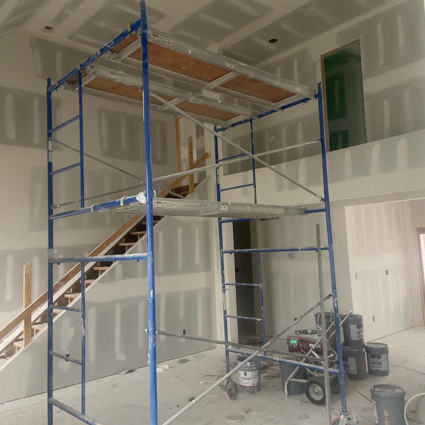 A blue scaffolding in a room with stairs