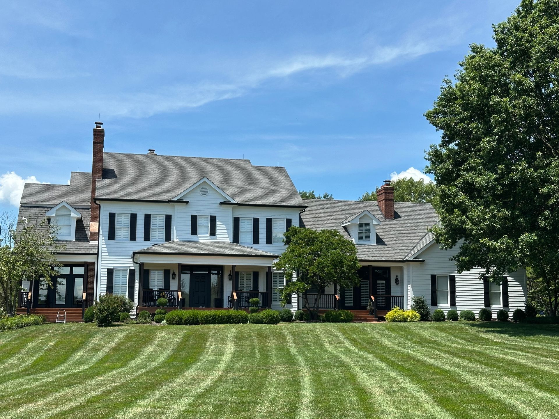 A large white house with a large lawn in front of it