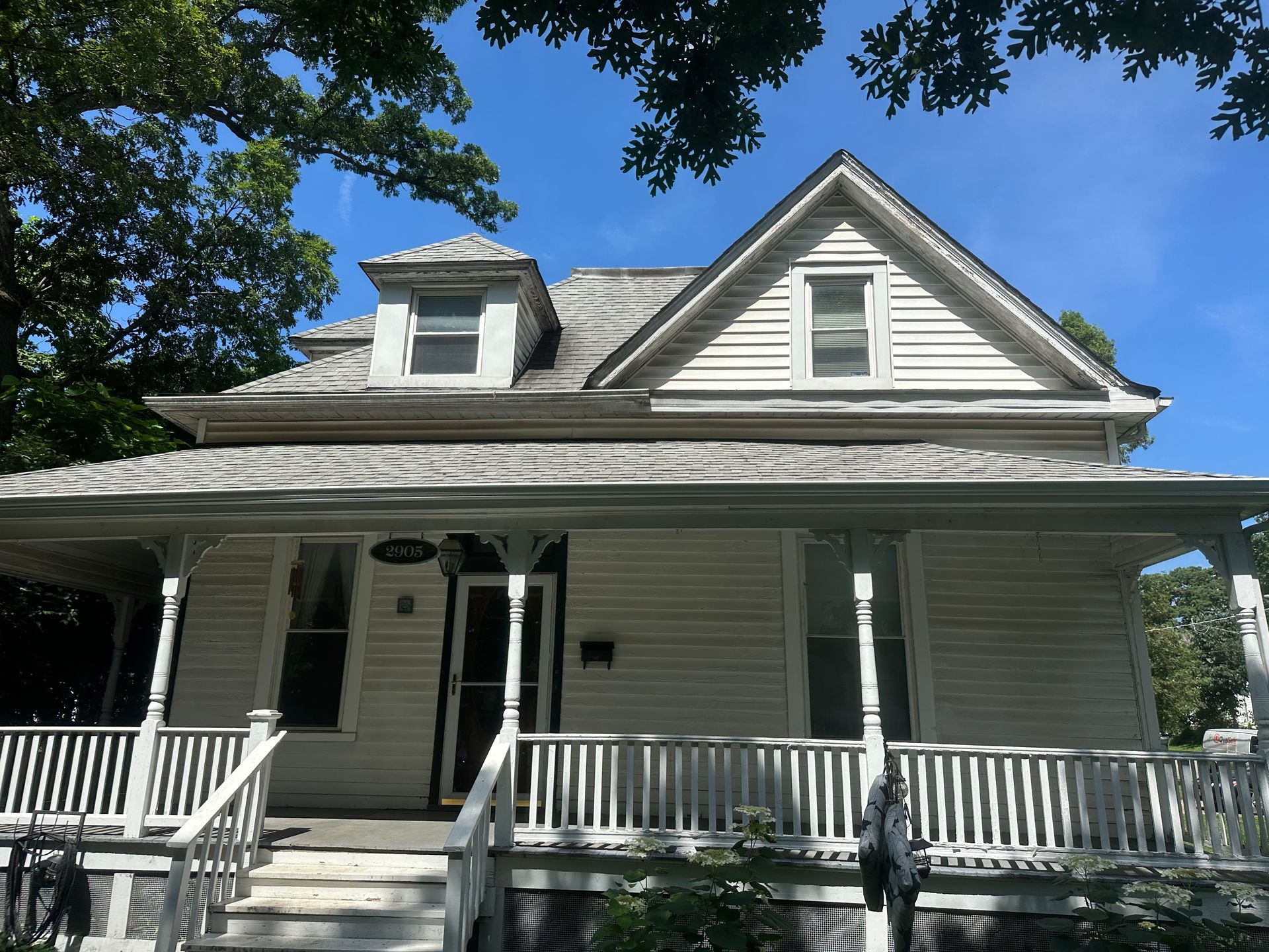 A white house with a porch on a sunny day