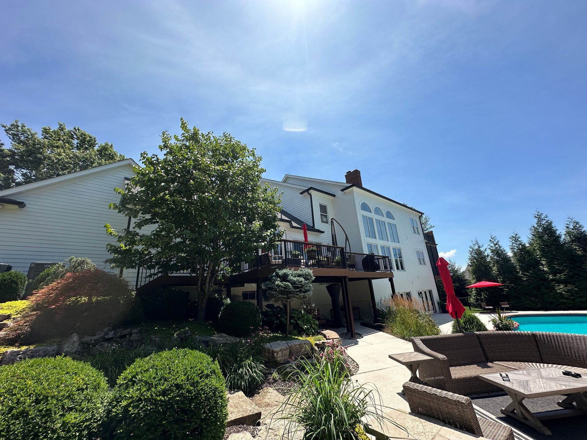 A large white house with a swimming pool in front of it.