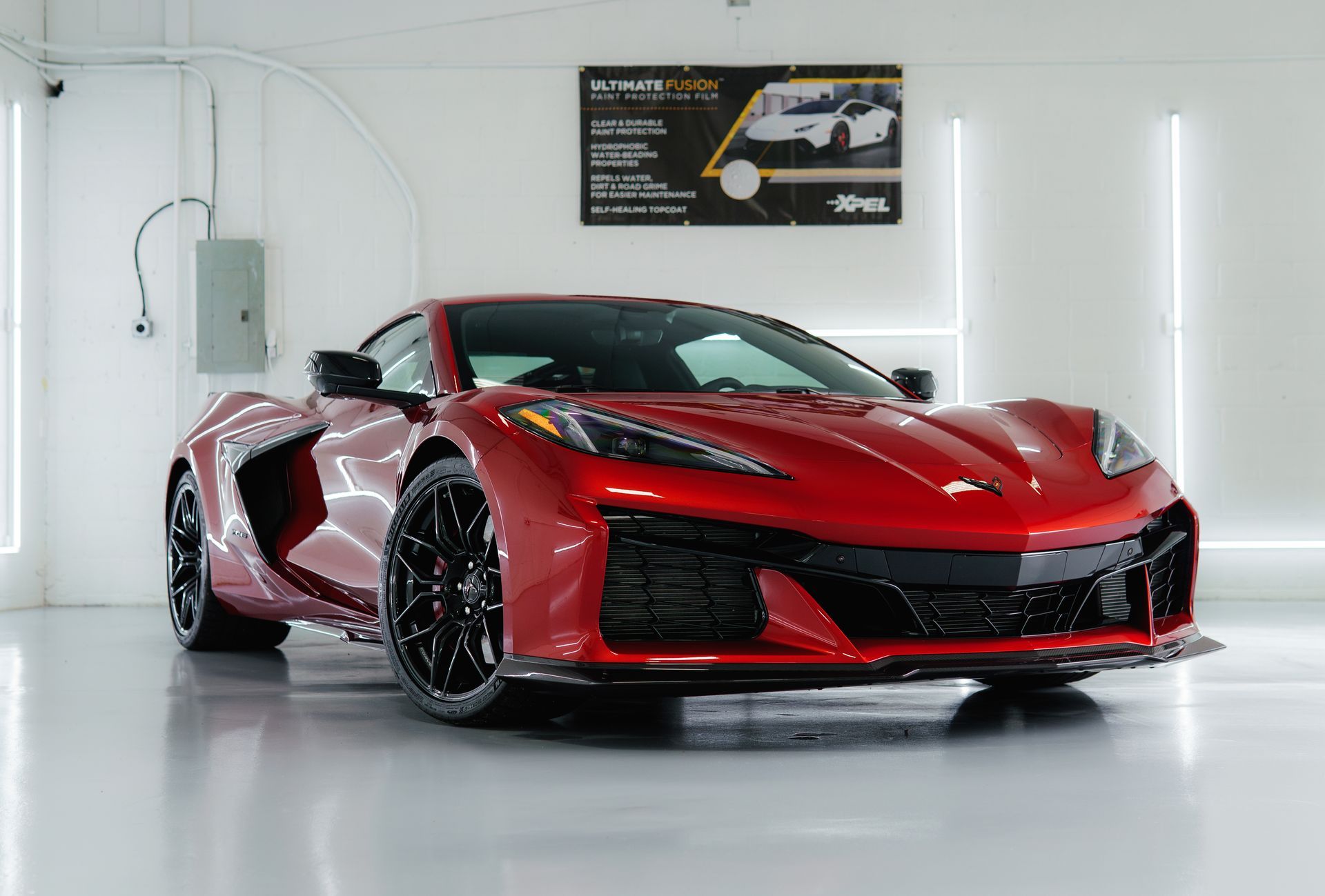 Red Corvette sports car in a bright white garage.