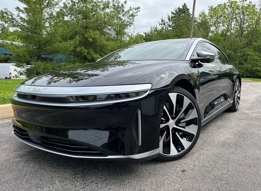 a black electric car is parked in a parking lot .