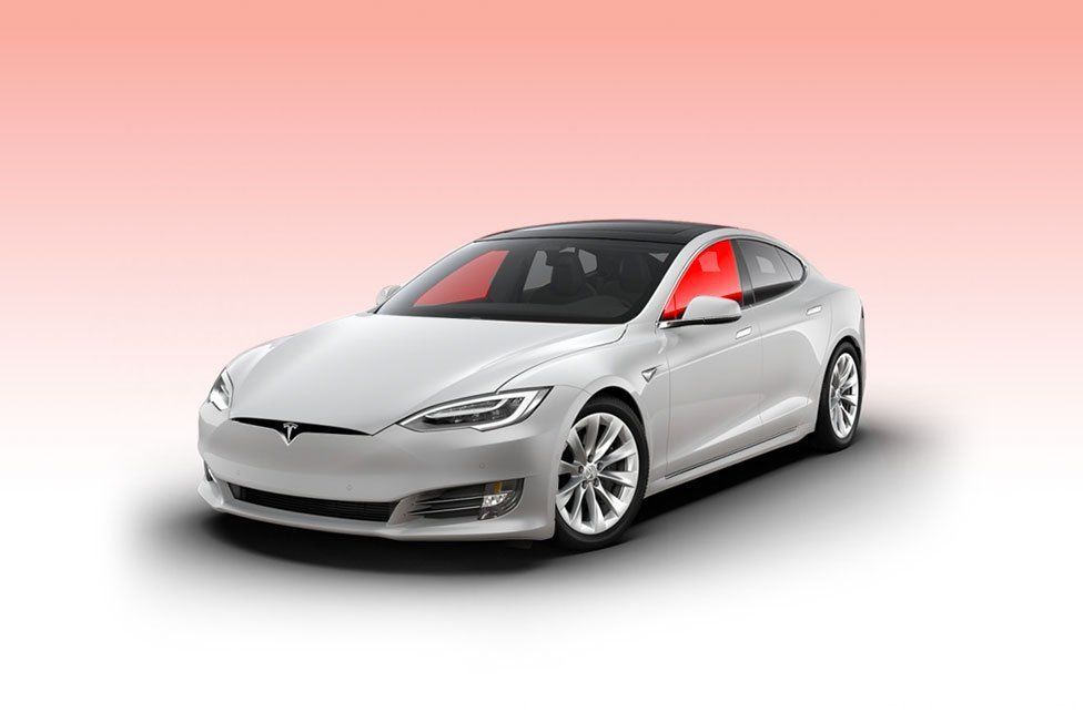 a white tesla model s is sitting on a pink background .