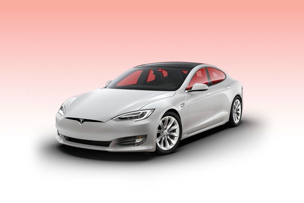 a white tesla model s is sitting on a pink background .