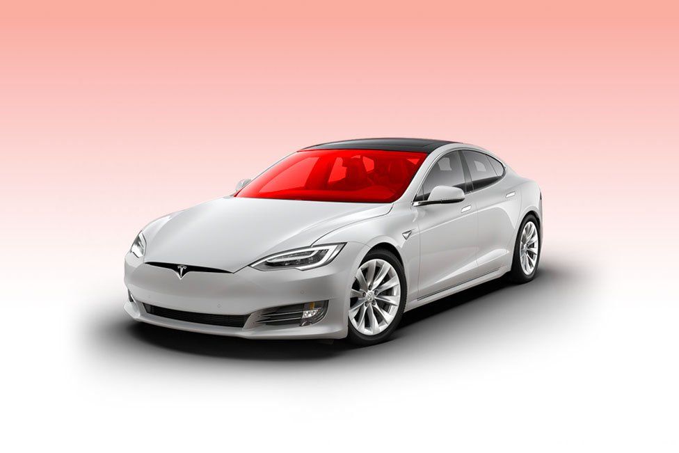 a white tesla model s with a red windshield on a pink background .