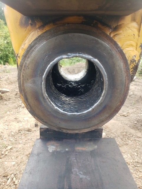 Yellow metal cylindrical machinery part with a hole.