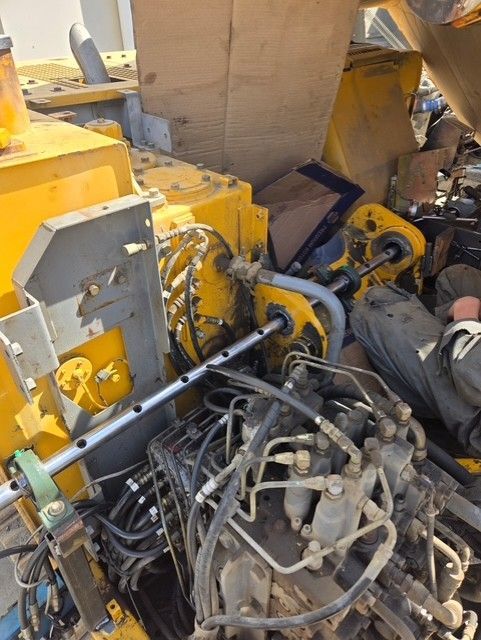 Yellow industrial machinery, hydraulic lines, and metal components.