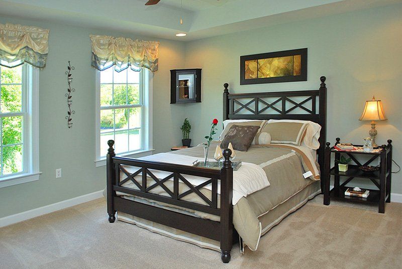 A bedroom with a large bed and two windows