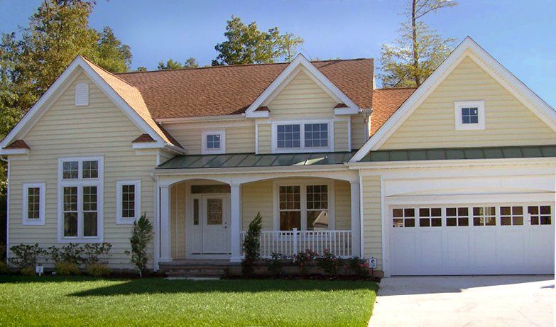 A large yellow house with a white garage door