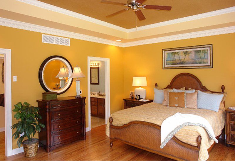 A bedroom with a large bed and a ceiling fan