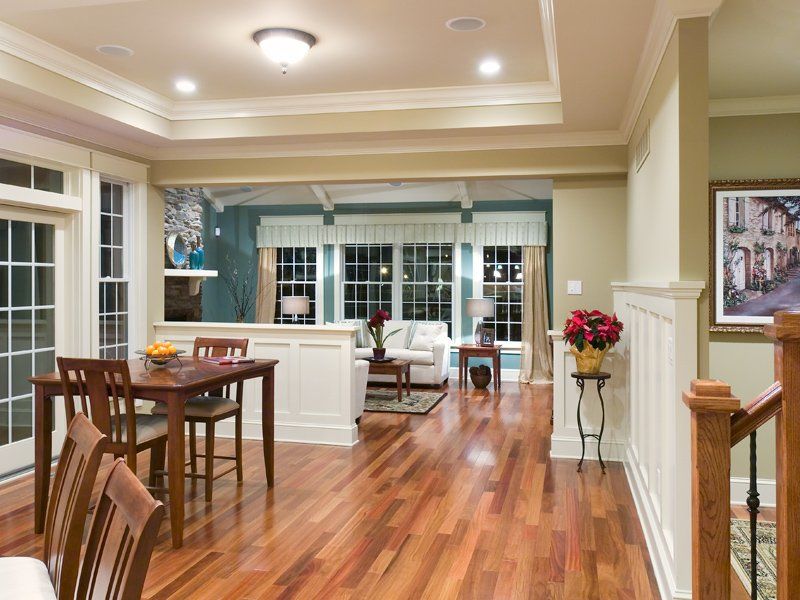 A living room with hardwood floors and a table and chairs
