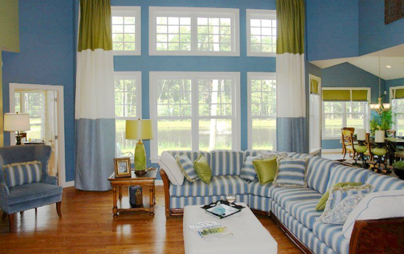 A living room with blue walls and a striped couch