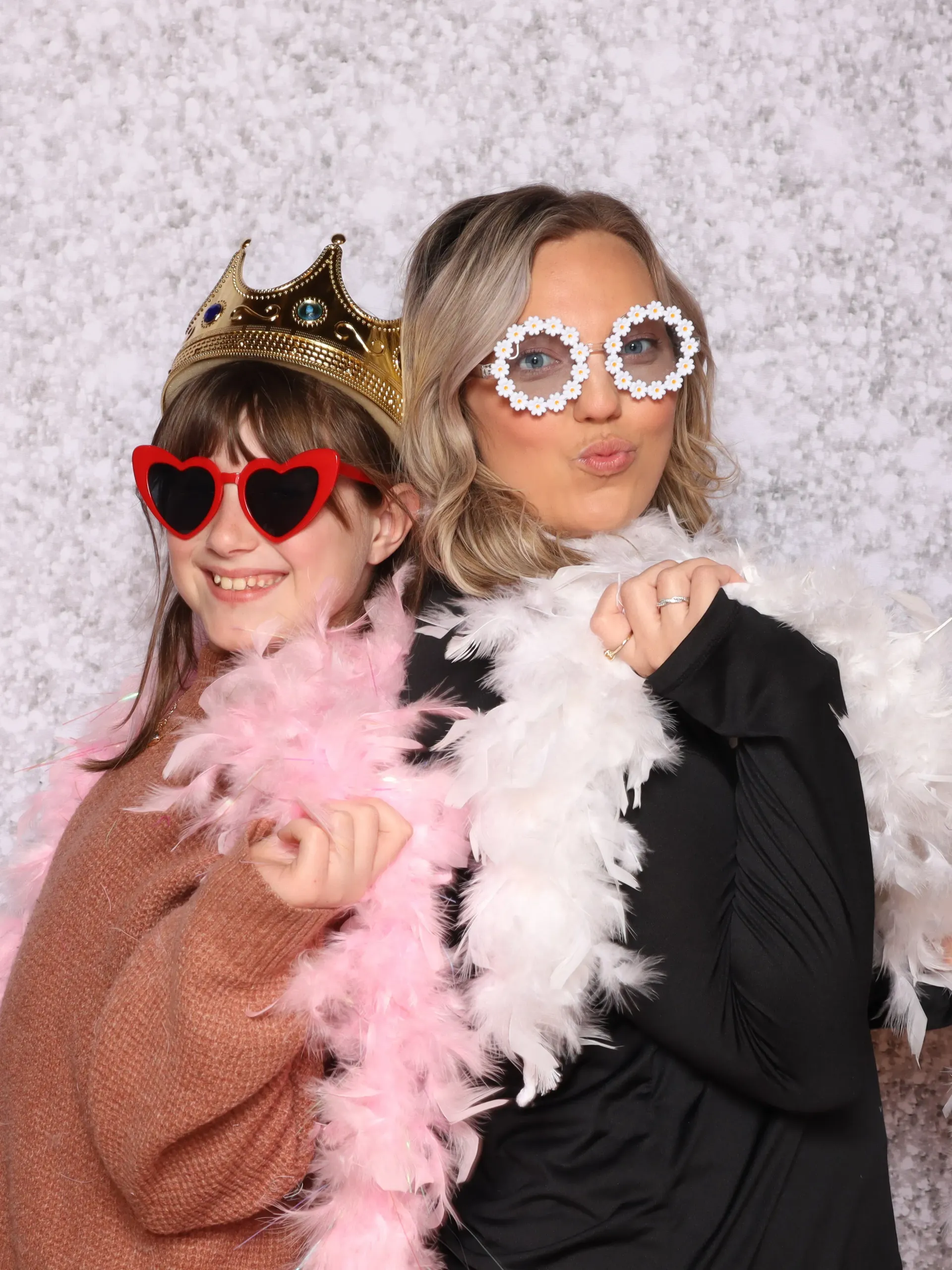 A woman and a girl are posing for a picture in a 302 photo booth.
