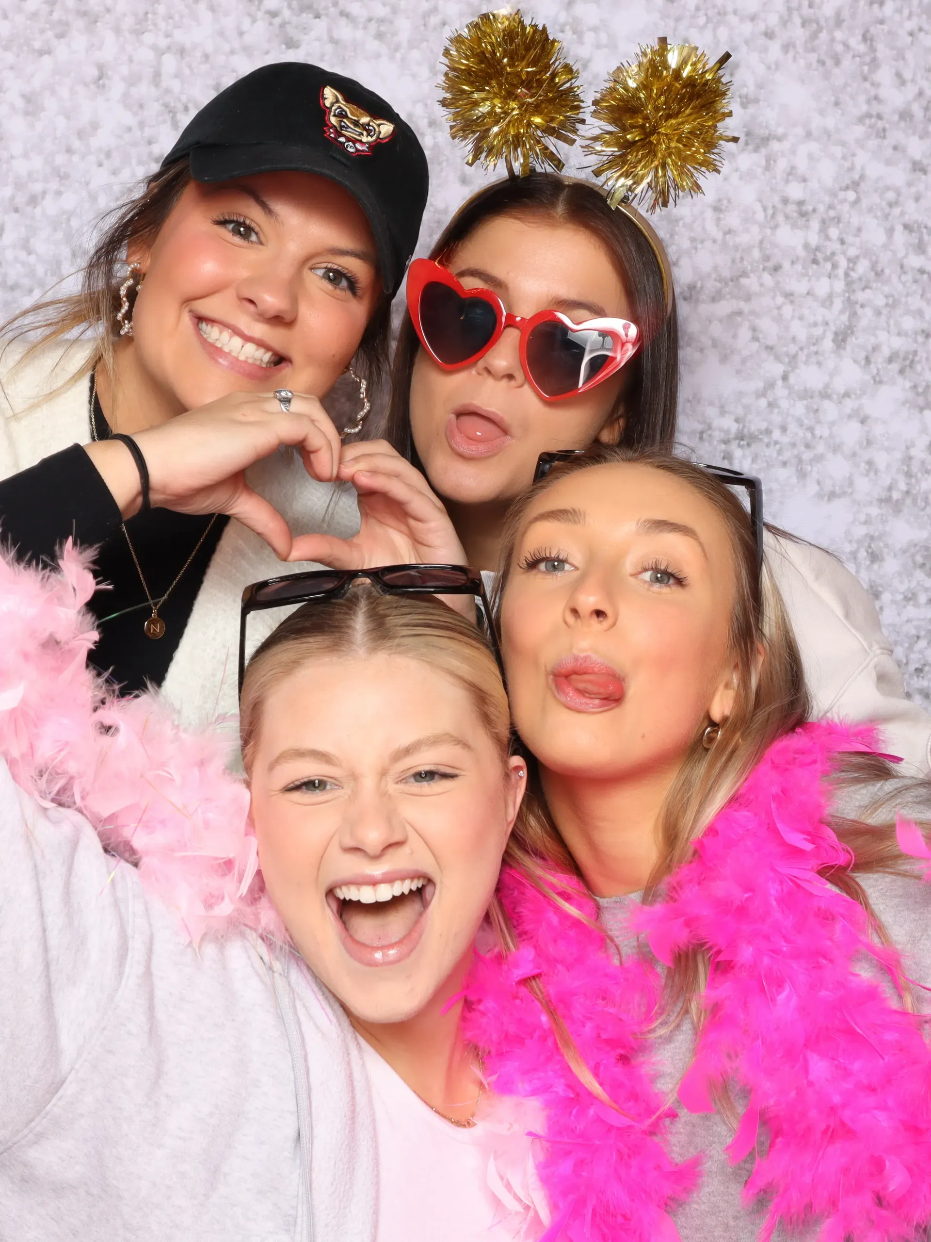 A group of young women posing for a picture in a 302 photo booth.