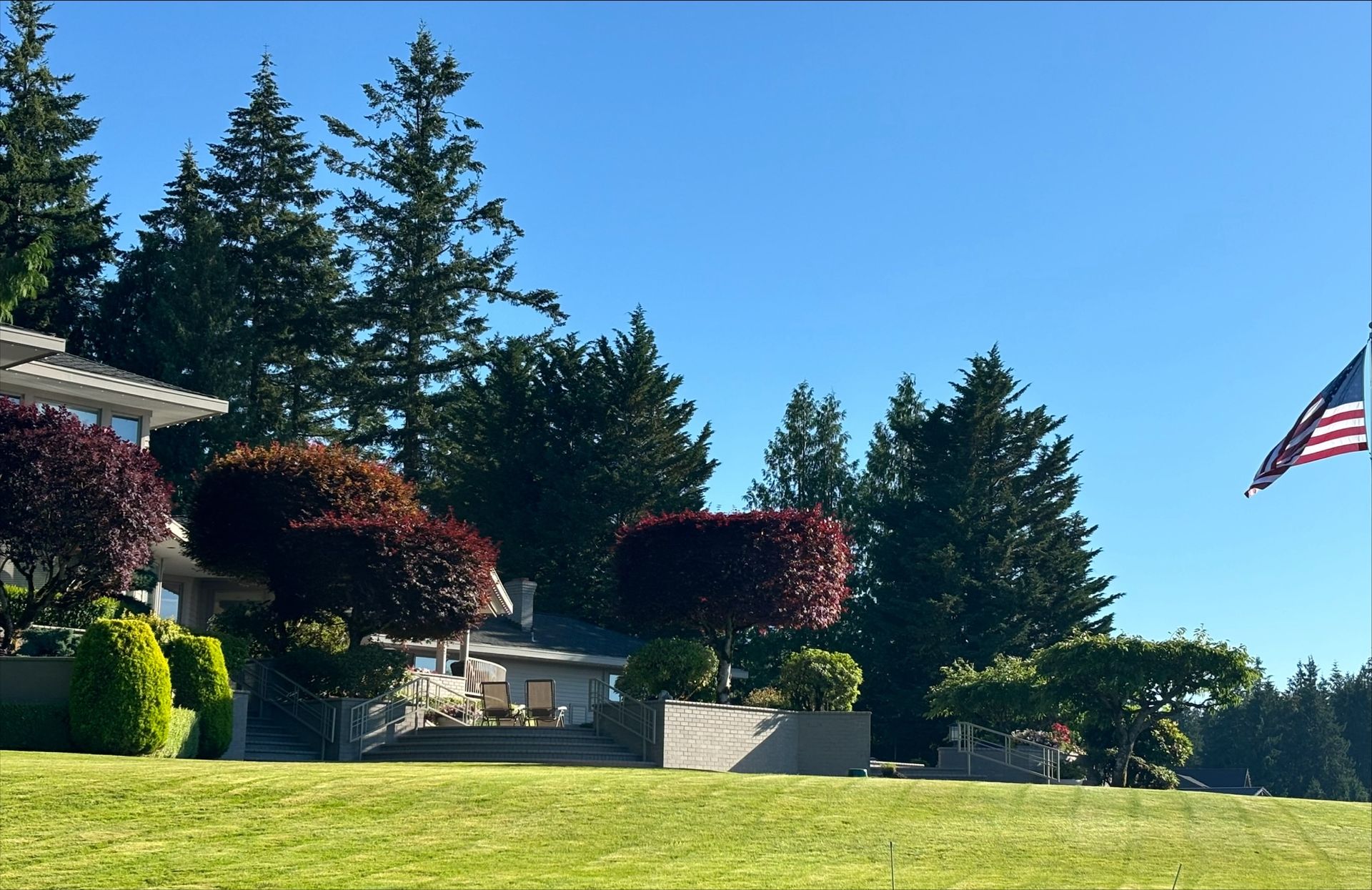 A man is mowing a lush green lawn with a lawn mower.