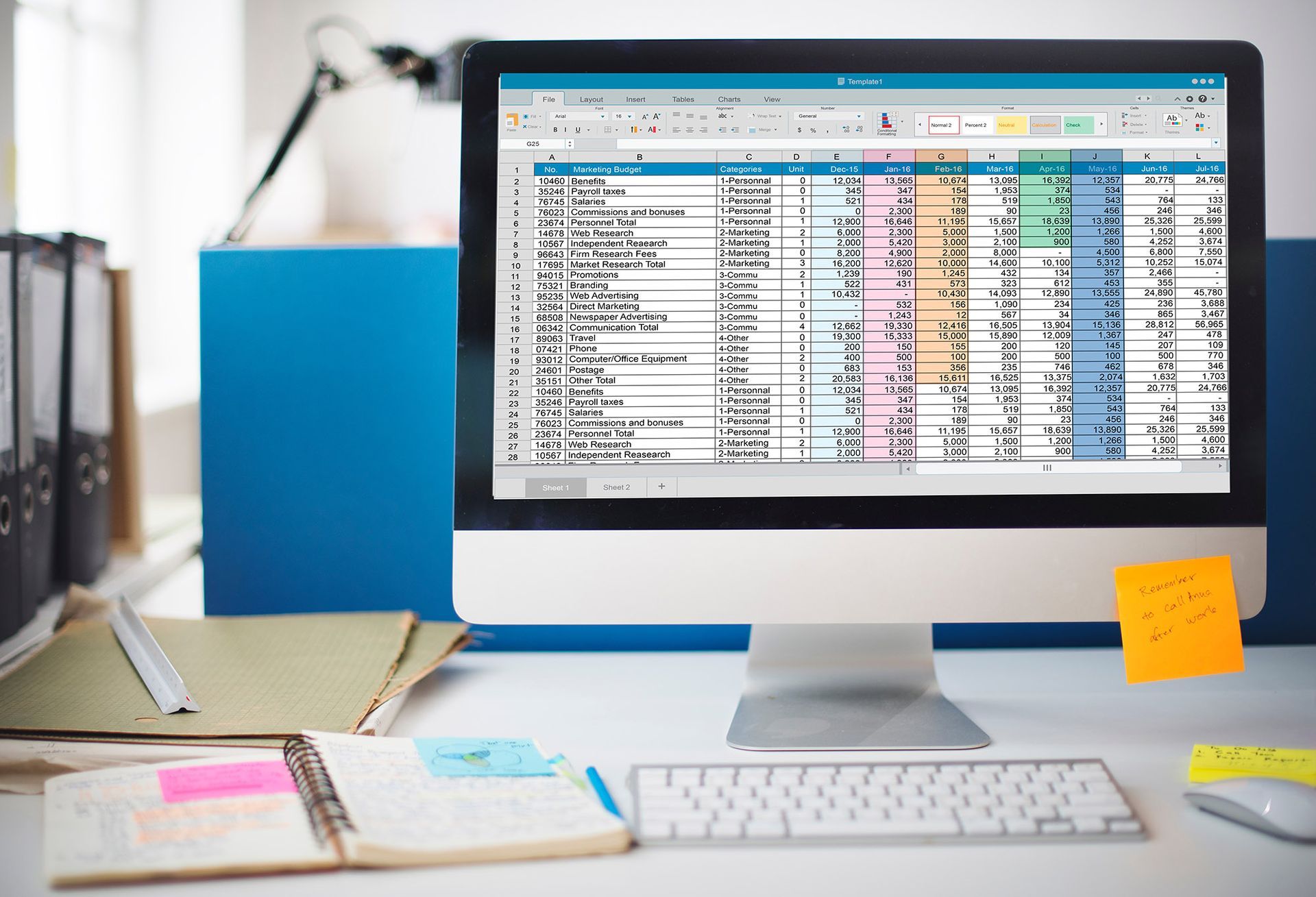 A computer screen displaying a colorful spreadsheet, on a desk with office supplies.