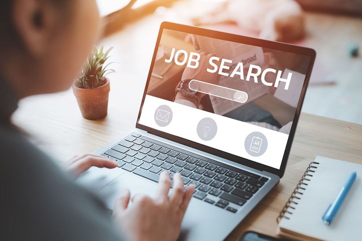 Person using laptop with "Job Search" on the screen, searching for work.