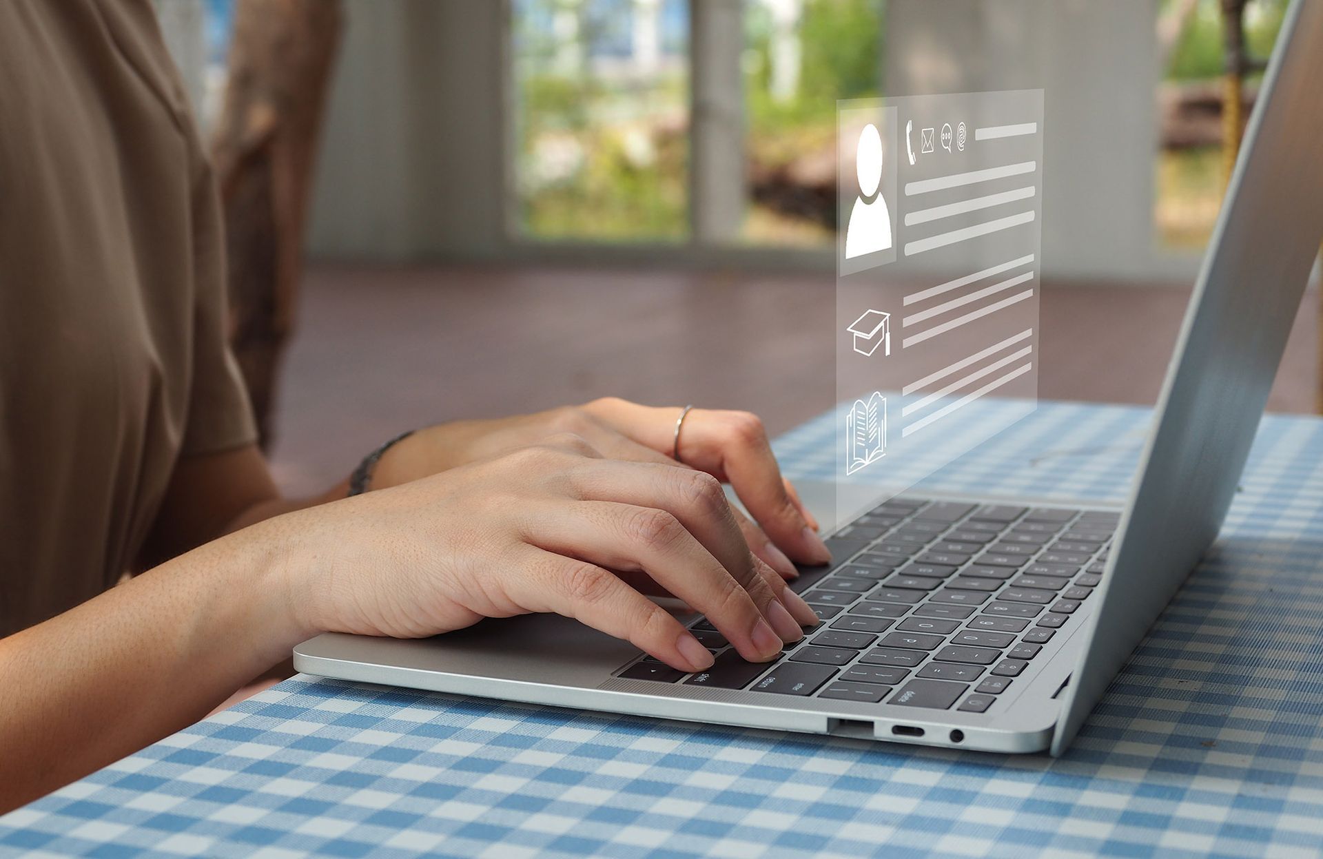 Person typing on laptop, overlaid with a digital profile display.
