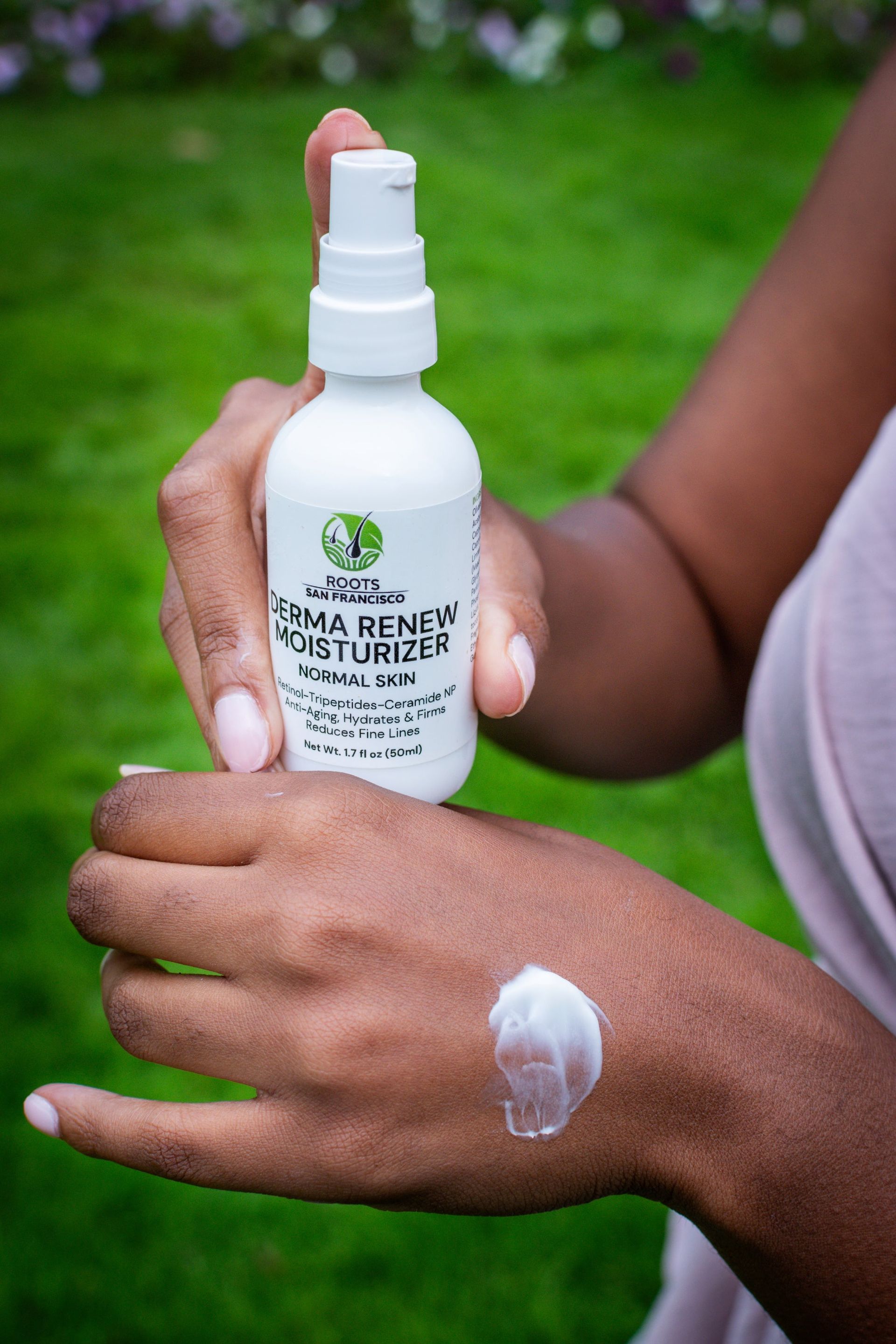 A woman is holding a bottle of moisturizer and applying it to her hand.