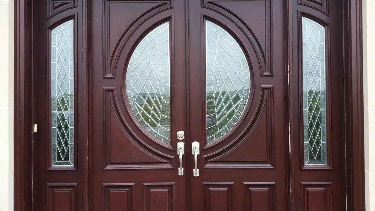 Double dark brown wooden front doors with glass panels and decorative accents.