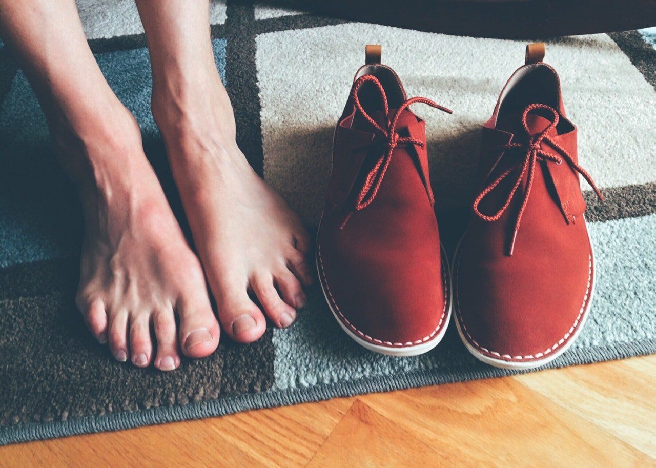 feet beside a pair of shoe