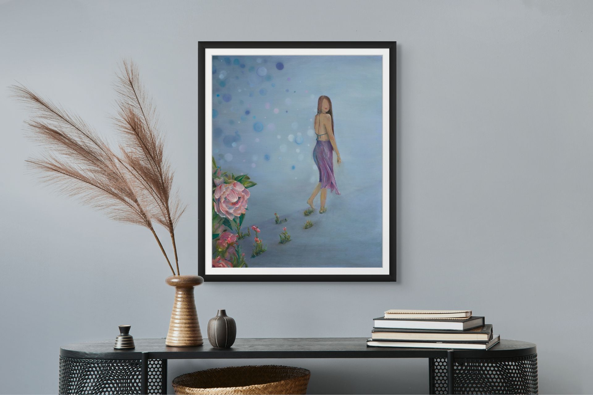 A painting of a woman is hanging on a wall above a table.
