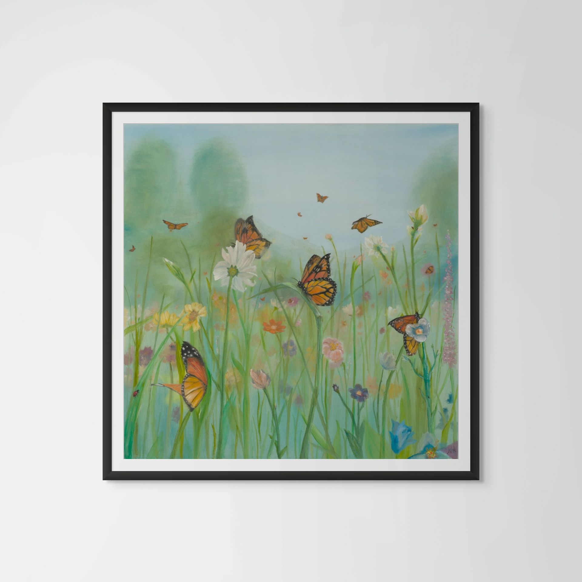 Woman silhouette blowing a butterfly, landscape within, in a black frame on a white wall.