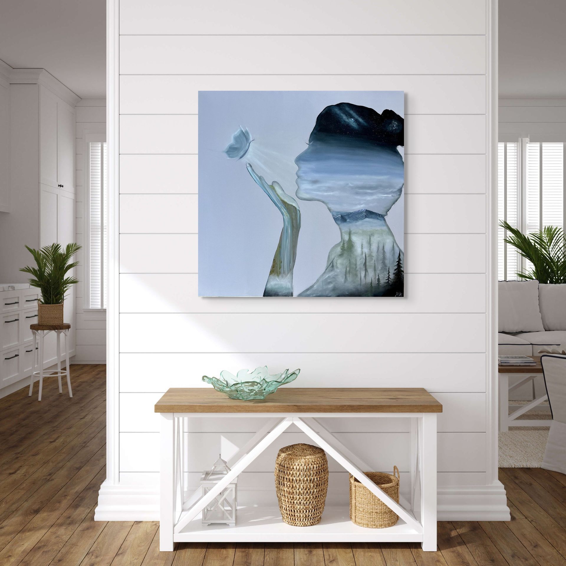 A painting of a bridge over a river is hanging on a wall above a wooden cabinet.