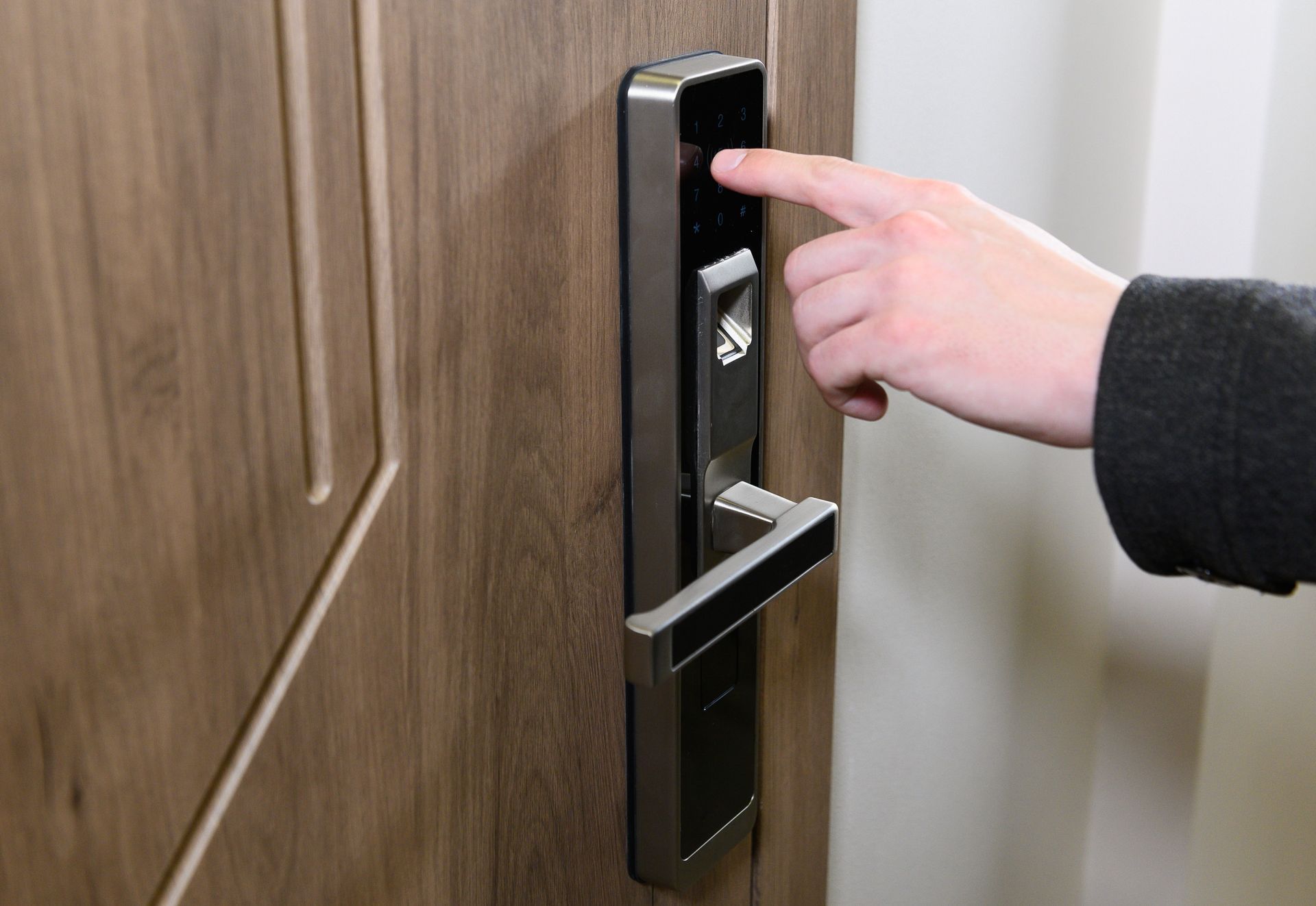 Person Using Fingerprint Scanner on a Wooden Door With a Silver Smart Lock — IRIS CCTV in South Grafton, NSW