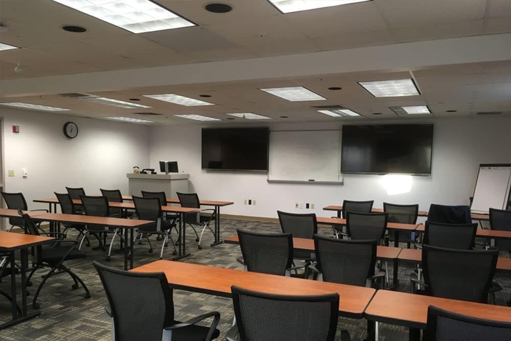 Empty Classroom With Rows of Desks and Chairs, Whiteboards, and Screens on the Wall — IRIS CCTV in Glen Innes, NSW