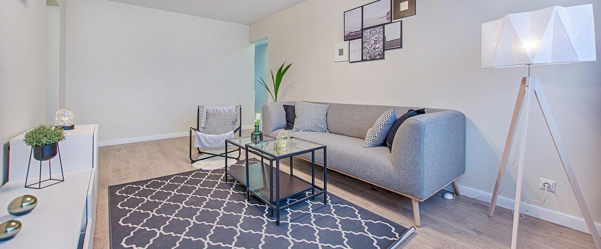 A cleaned living room by Mountain Tops Cleaning Service with a couch , chairs , a rug and a lamp.