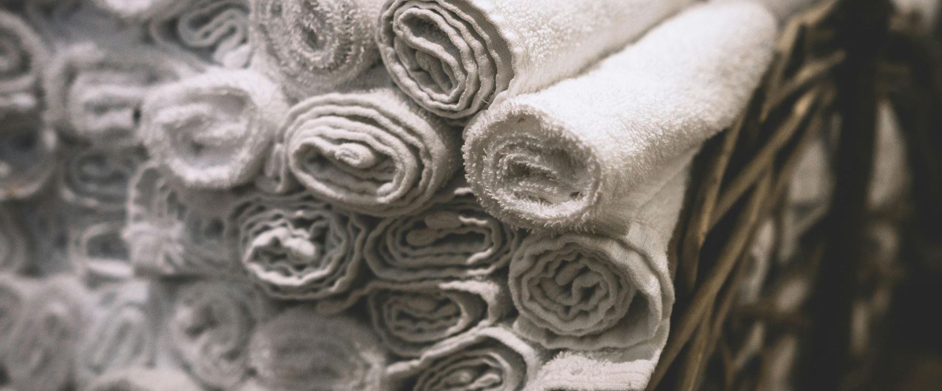 A bunch of towels are rolled up and stacked on top of each other by Mountain Tops Cleaning Service.